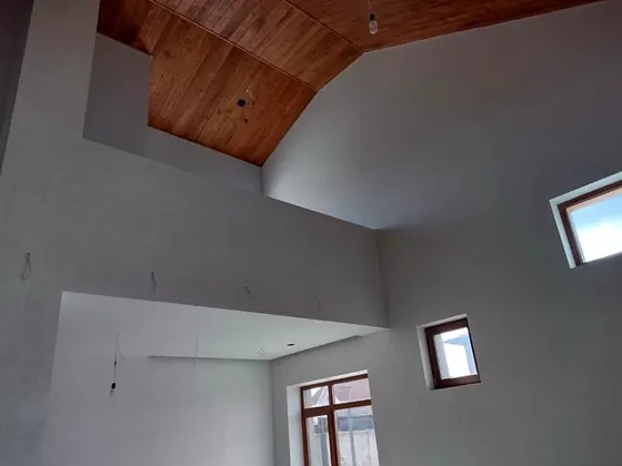 Ausgebauter Dachraum mit Holzdecke und verputzten Wänden