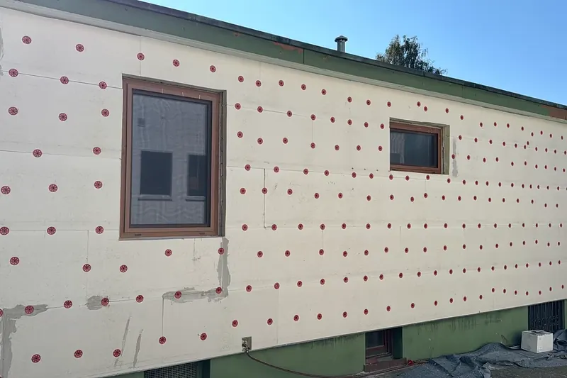 Hausfassade mit angebrachten und verdübelten Dämmplatten vor dem Verputzen